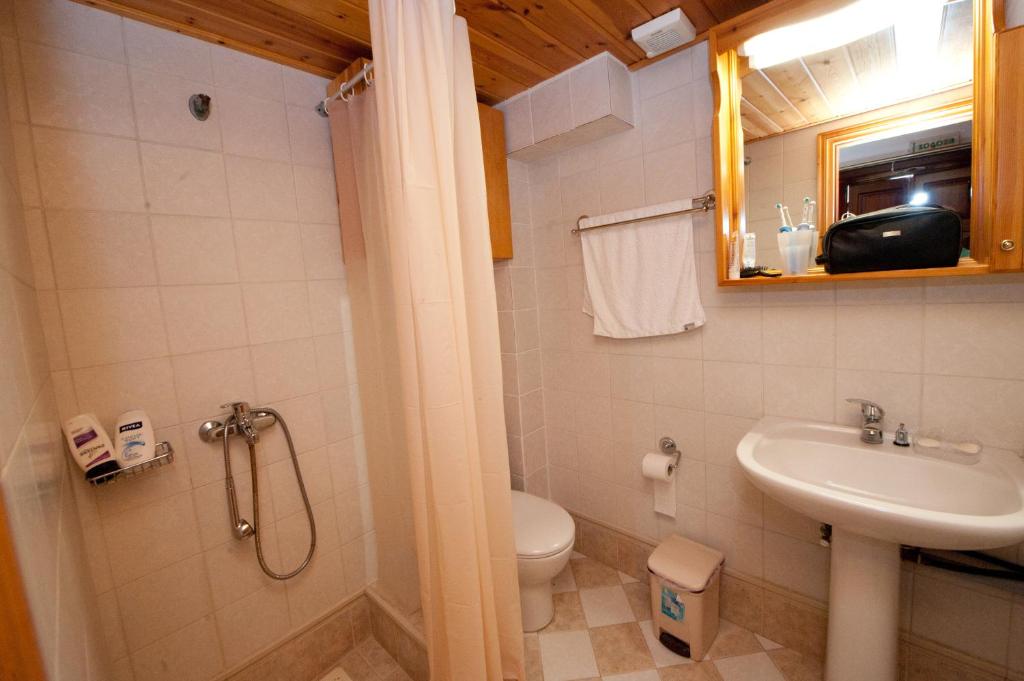 a bathroom with a toilet and a sink at Odyssia in Symi