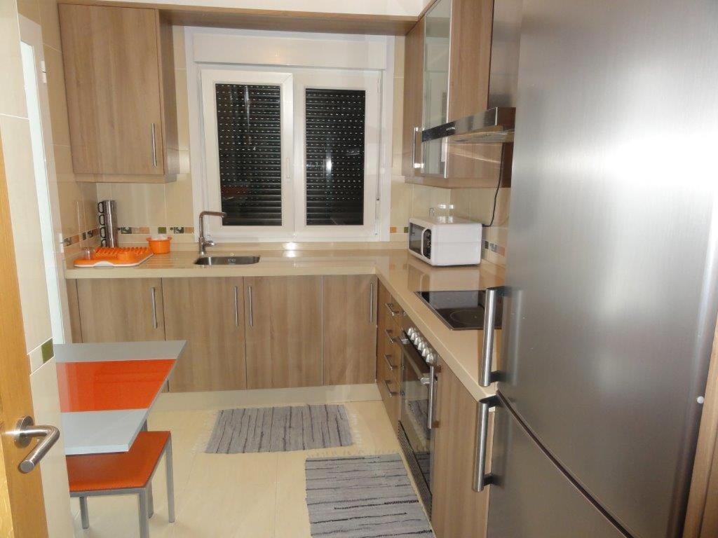 a kitchen with a stainless steel refrigerator and a window at Apartamento Playa Langosteira in Finisterre