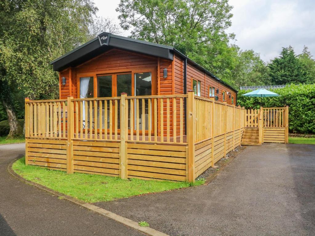 a wooden cabin with a gate and a fence at Luca's Lodge in Windermere