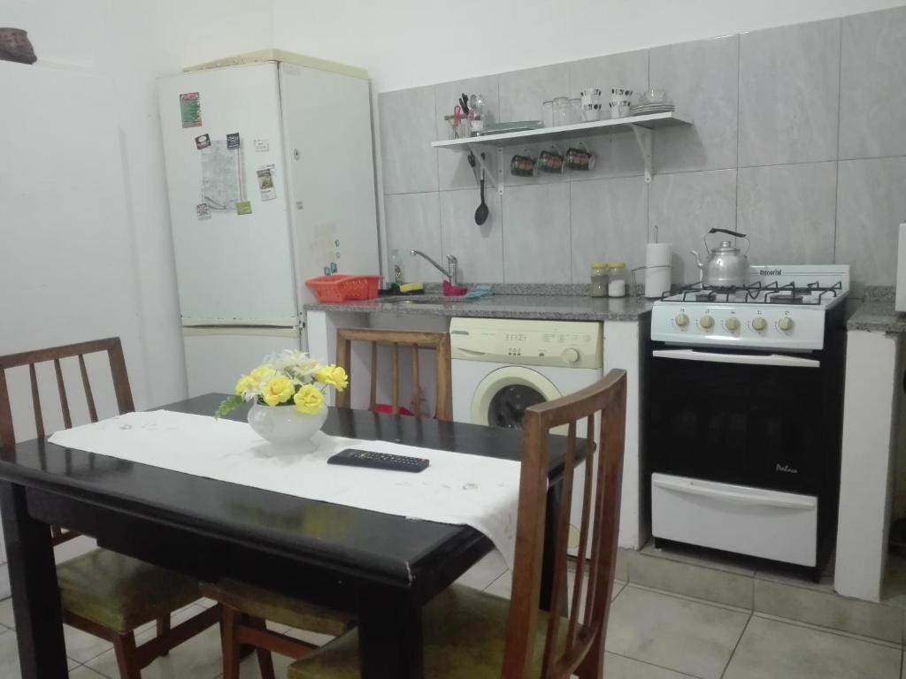 eine Küche mit einem Tisch und eine Küche mit einem Herd in der Unterkunft Departamentos La Tita in Concepción del Uruguay