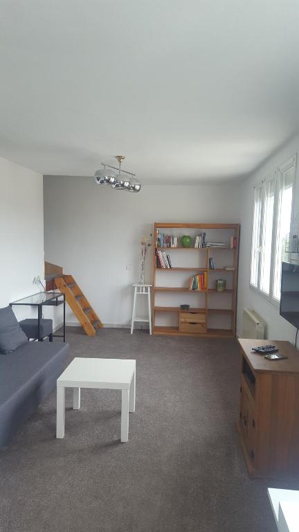 a living room with a white couch and a table at Duplex à 5 min aéroport Orly - 15 min Paris in Athis-Mons