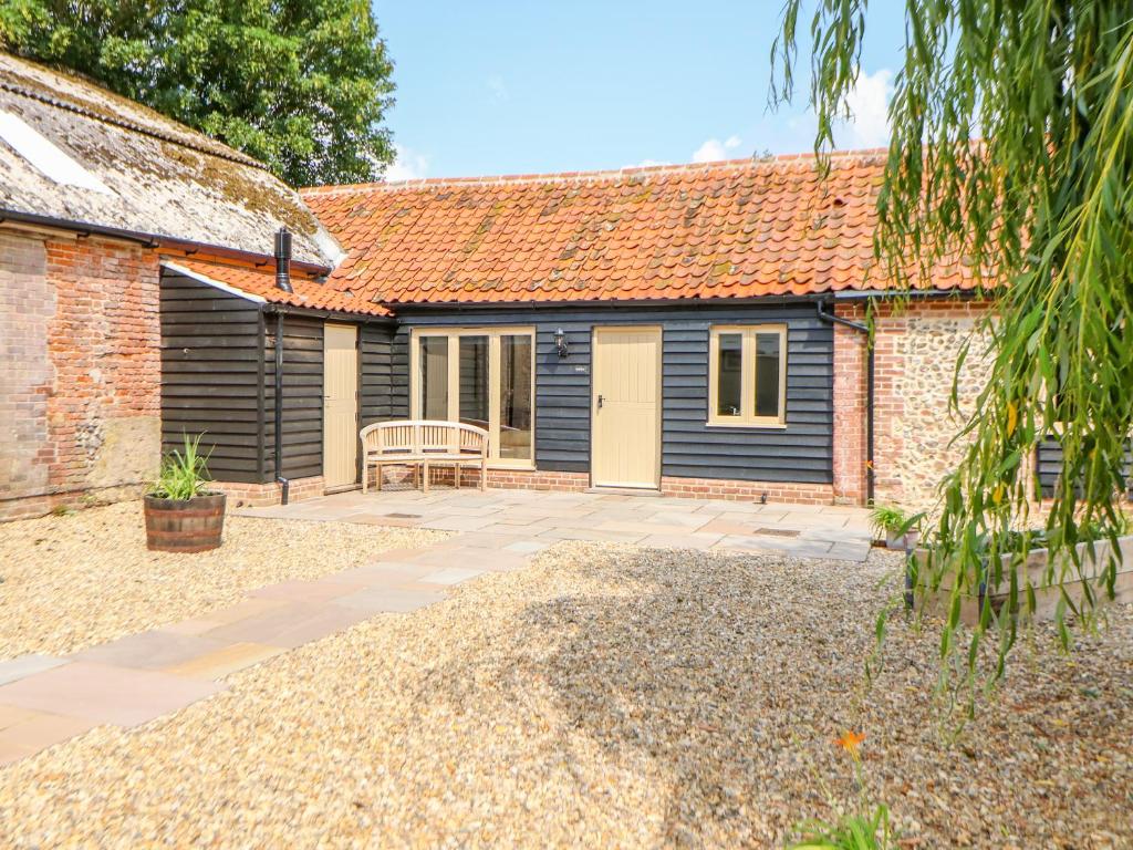 a cottage with a patio in front of it at The Stables in East Dereham