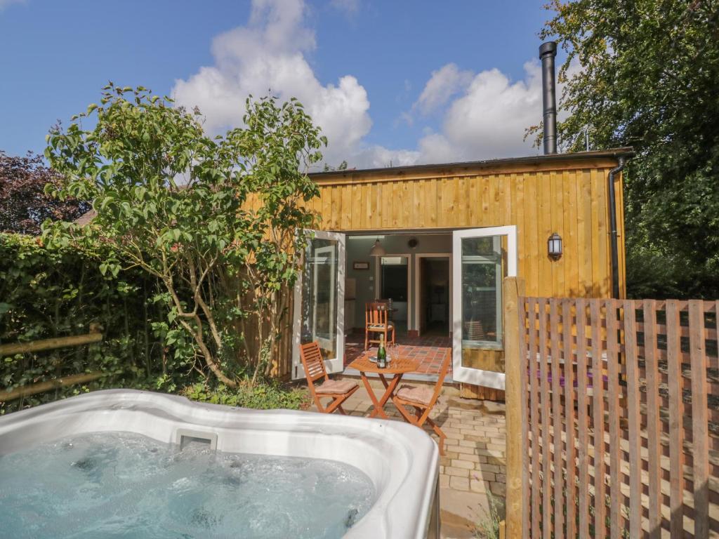 uma pequena casa com uma banheira de hidromassagem no quintal em Hen House View em Rugeley