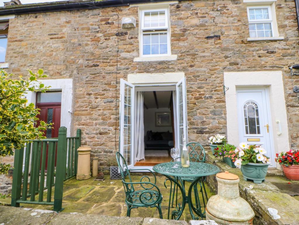 a table and chairs in front of a brick house at 2 West Haswicks in Bishop Auckland