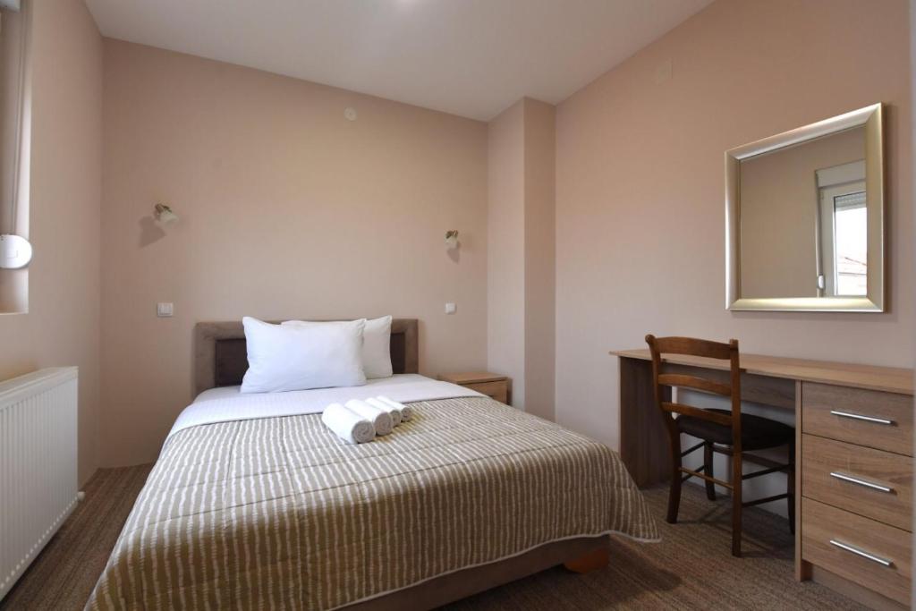 sypialnia z łóżkiem, biurkiem i lustrem w obiekcie Olimp w mieście Kraljevo