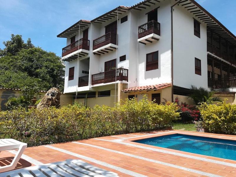 a building with a swimming pool in front of a building at El Retiro Barichara 206 in Barichara