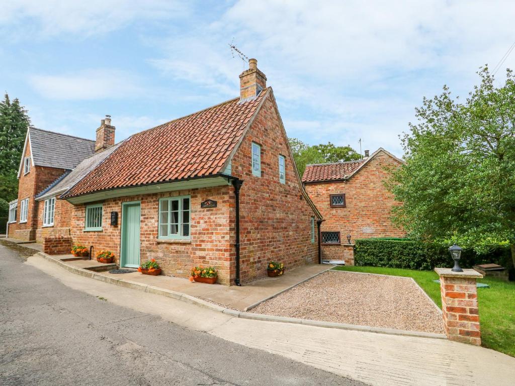 a brick house with a red roof on a street at Lizzies Cottage in Horncastle