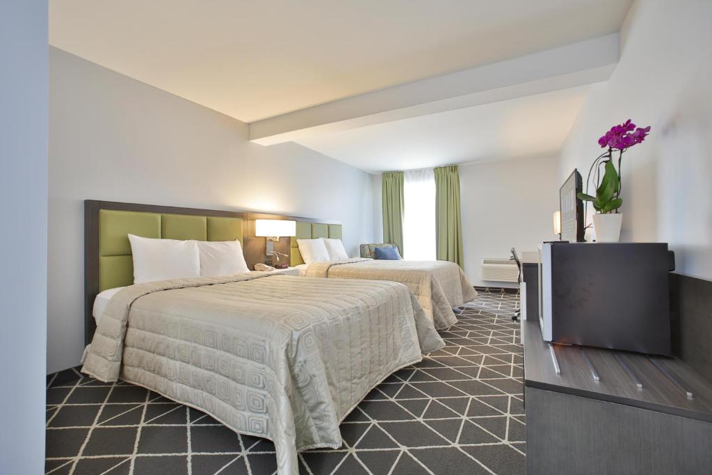 ein Hotelzimmer mit 2 Betten und einem TV in der Unterkunft King Hotel in Palmerston