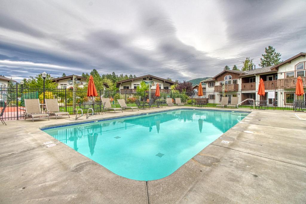 a swimming pool with chairs and umbrellas at Icicle Village Resort 508: Alpine Aurora in Leavenworth