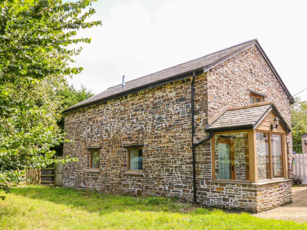 an old stone house with a window on the side of it at The Shippon in Barnstaple