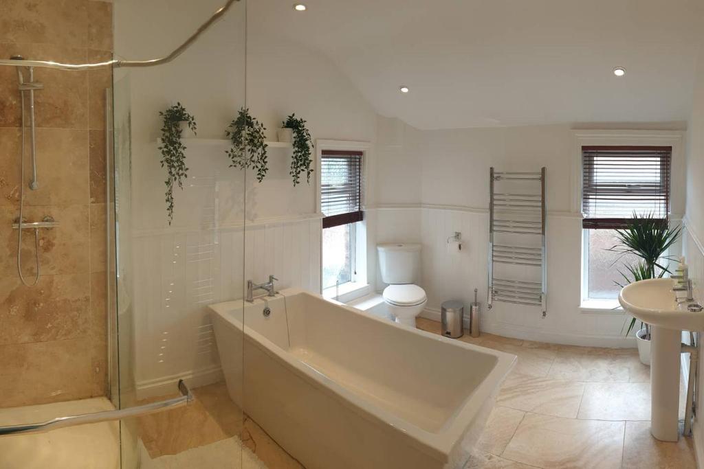 a bathroom with a tub and a toilet and a sink at 8 bed house 2 miles (7 Mins) from Newcastle centre in Newcastle upon Tyne