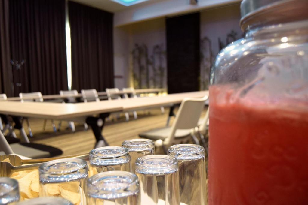 a table with a mason jar of drink in front of a hall at Hotel River Poliforum in Le&oacute;n