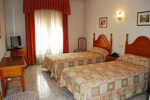 A bed or beds in a room at Hostal Universal