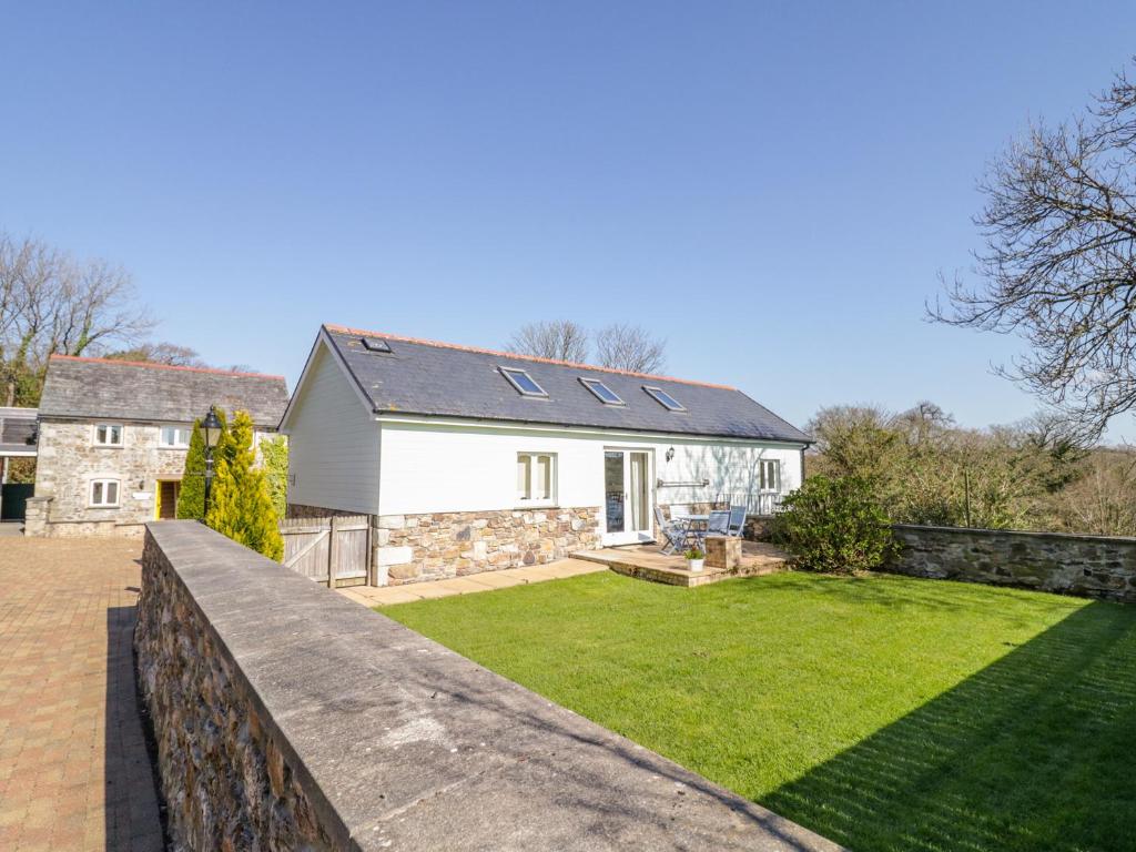 a home with a stone fence and a yard at Forget-me-not in Saint Columb Major