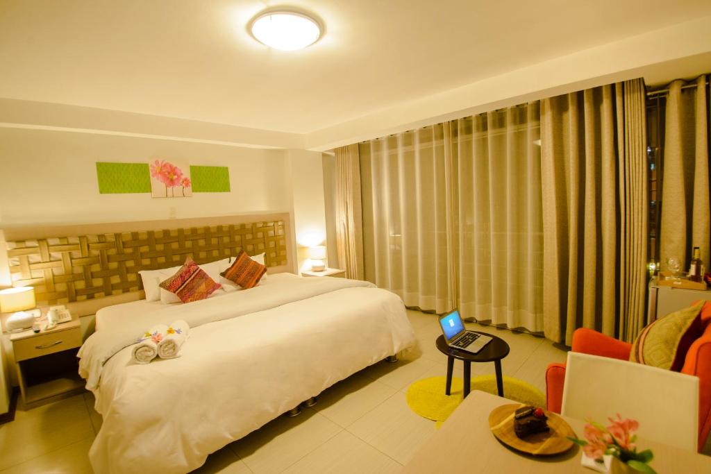 ein Hotelzimmer mit einem großen Bett und einem Sofa in der Unterkunft Wayta Inn in Cusco