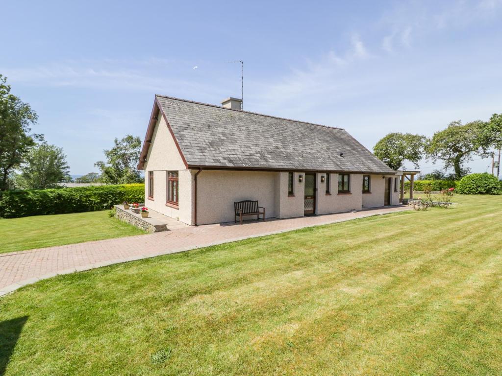 a small white building with a large grass field at Berwyn in Talybont