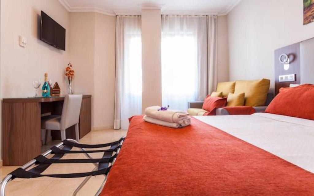 1 dormitorio con 1 cama grande con alfombra roja en Triana L, en Sevilla