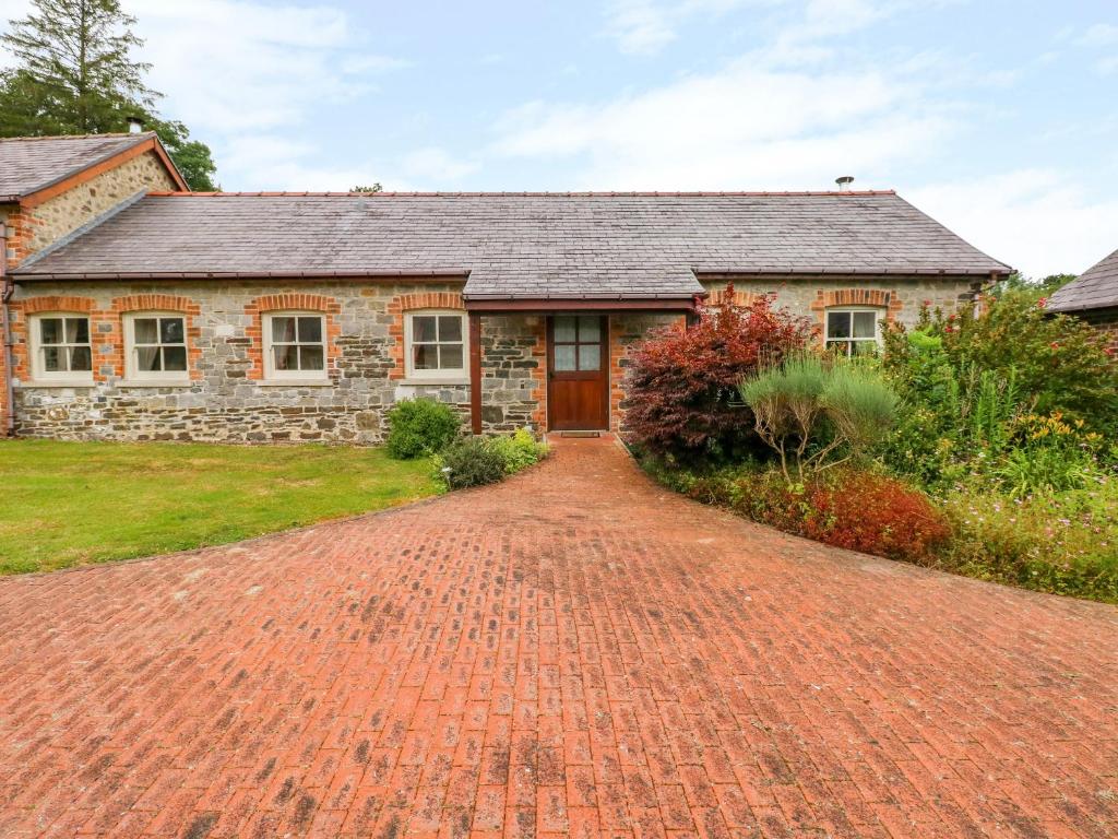 a brick driveway in front of a stone house at Taf Cottage in Carmarthen