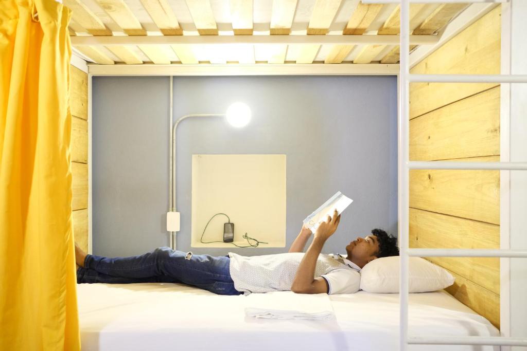 a woman laying on a bed reading a book at Casa Tunido in Santa Marta