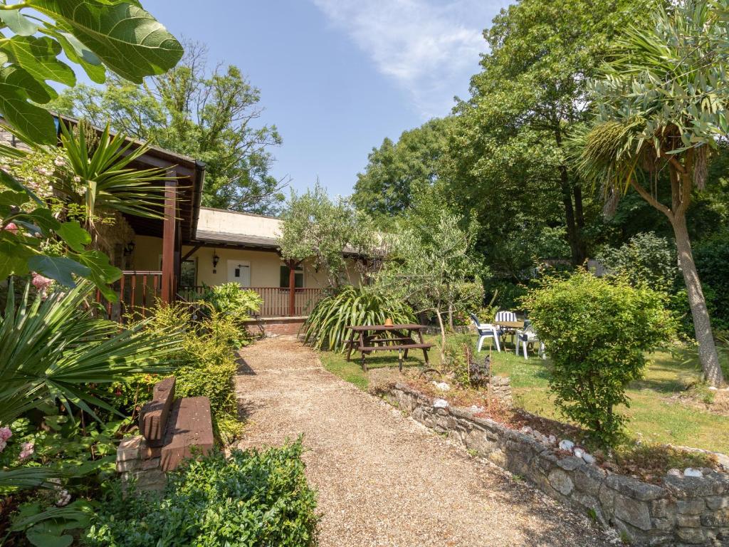 a cottage with a garden and a path at Riverhouse Lodge in Upwey