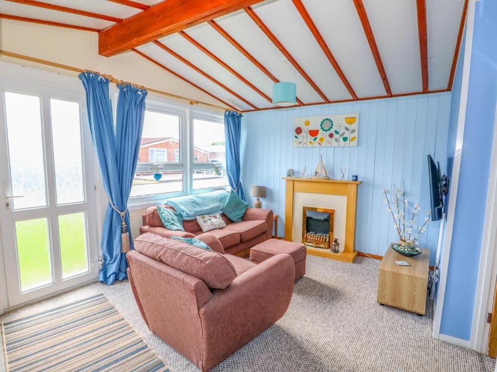 a living room with a couch and a fireplace at Moggs Retreat in Skegness