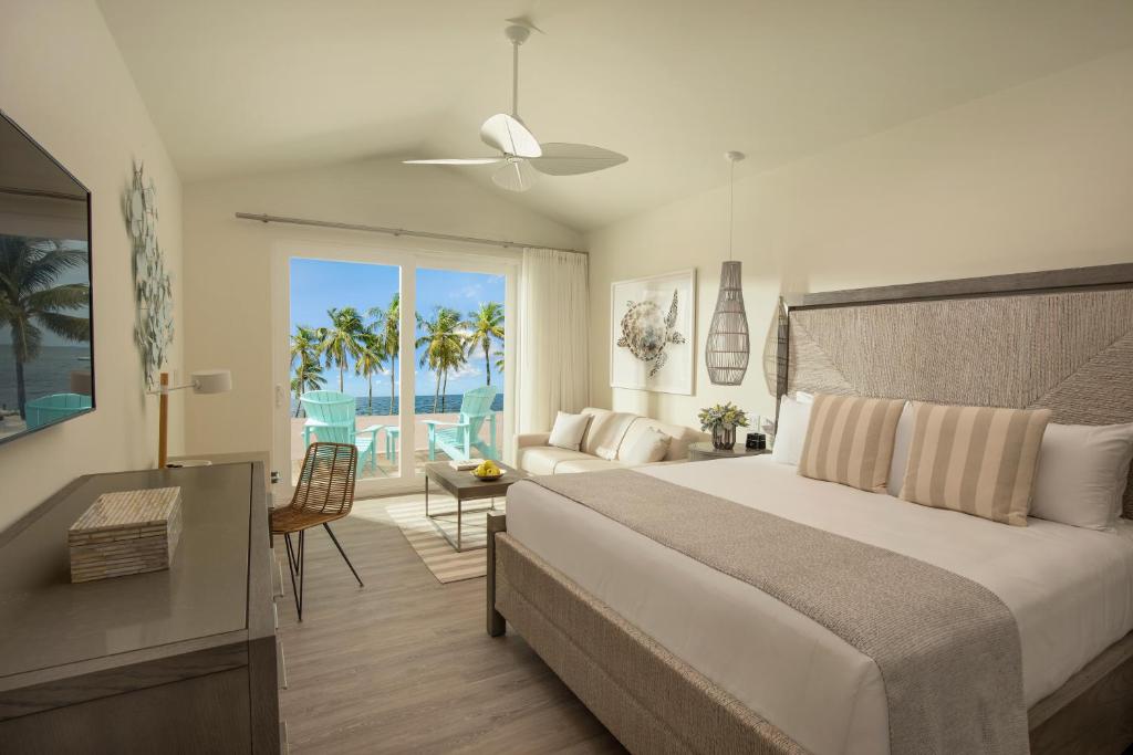 a bedroom with a large bed and a large window at Bungalows Key Largo - All Inclusive in Key Largo