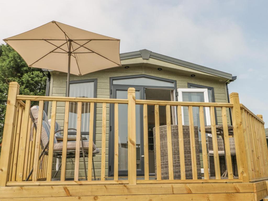 a deck with a chair and an umbrella at The Sequoia in Scarborough