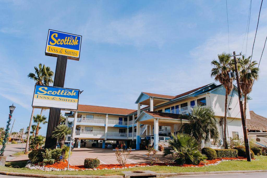 a hotel with a sign for a resort at Scottish Inn & Suites - Kemah Boardwalk in Kemah