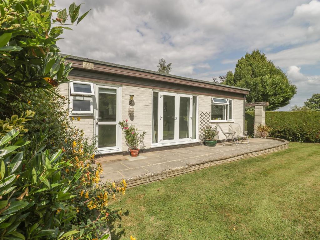 a cottage with a patio and a yard at Orchard Annexe in Lymington