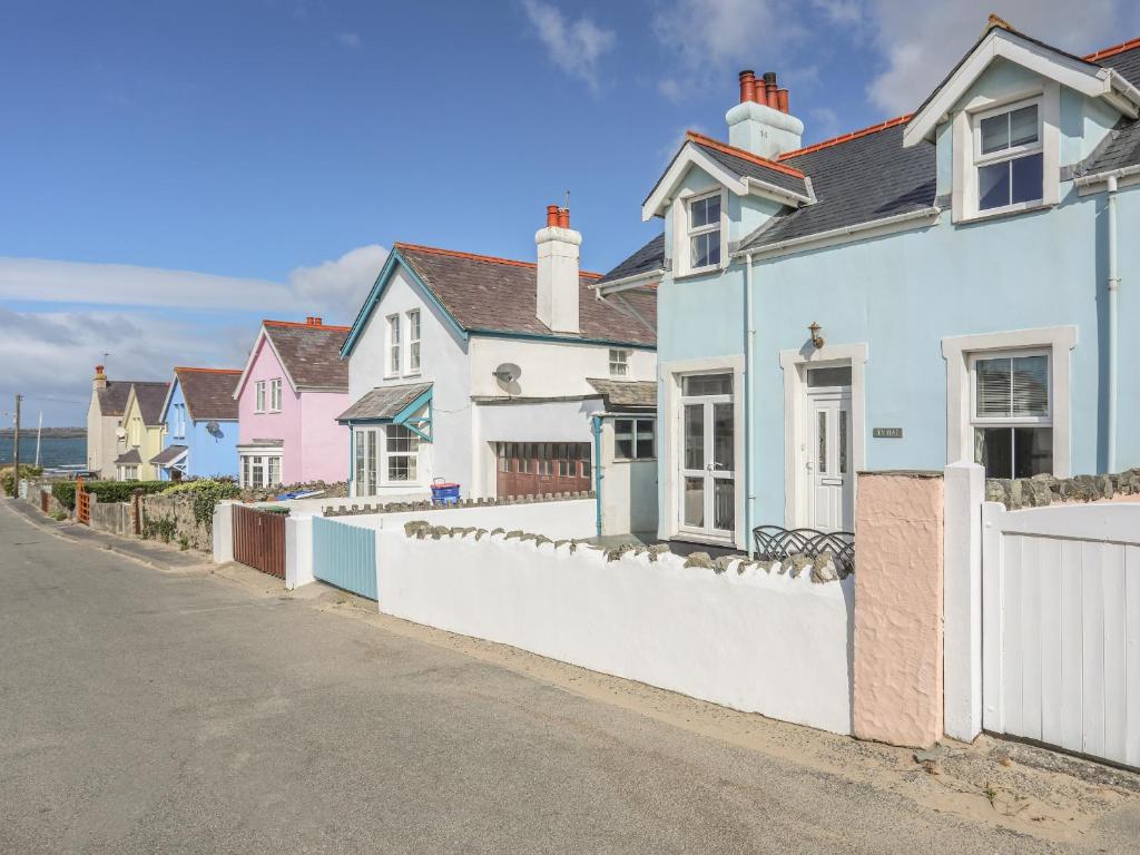 a row of houses on a street with a white fence at Ty Haf in Rhosneigr