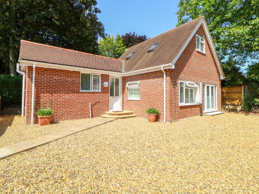 een rood bakstenen huis met een grindoprit bij The Lodge at Orchard House in Norwich