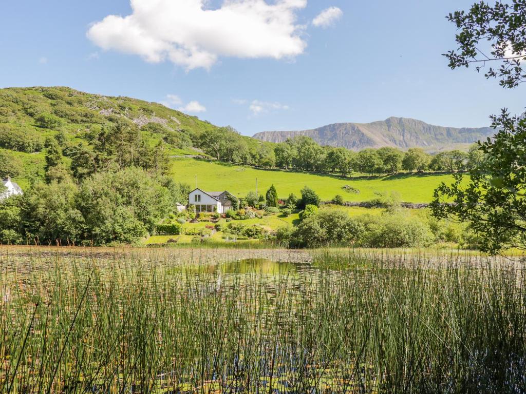 a house on a hill next to a body of water at Nant Y Gwernan in Dolgellau