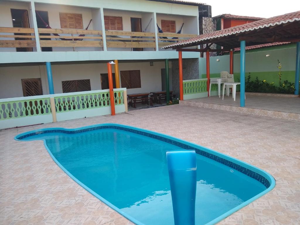 a blue swimming pool in front of a building at Pousada Terraço Potiguara in Baía da Traição