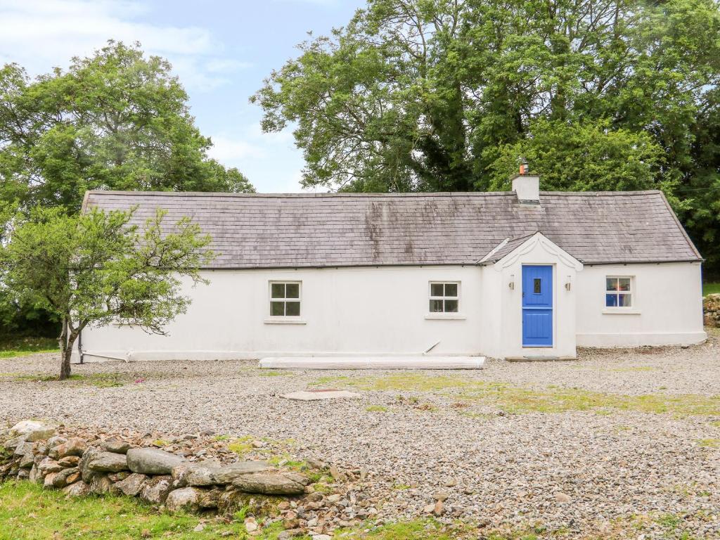 a white cottage with a blue door at The Old White Cottage in Shillelagh