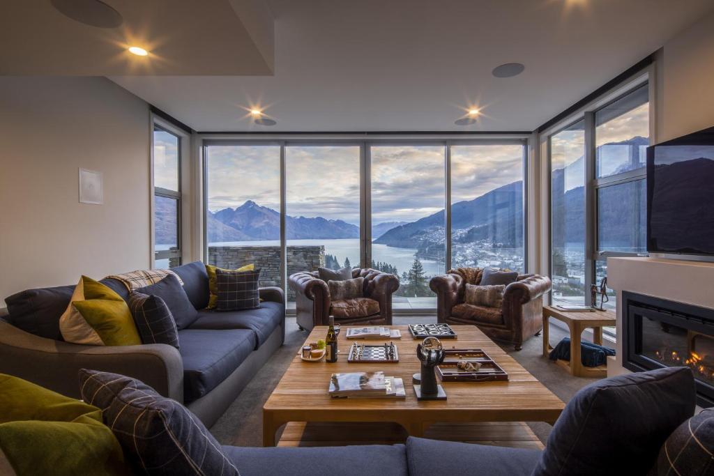 a living room with couches and a table at Lago Infinito by Sotheby's Luxury Rental Homes in Queenstown