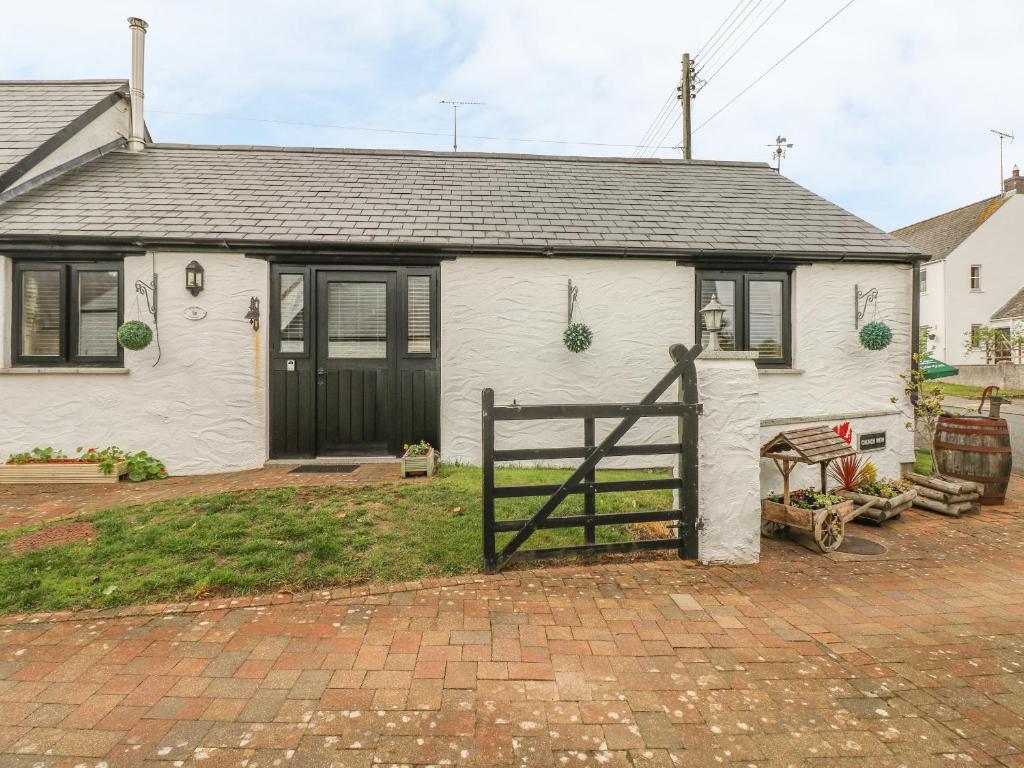 een wit huis met een hek ervoor bij Cowslip Cottage in Milford Haven