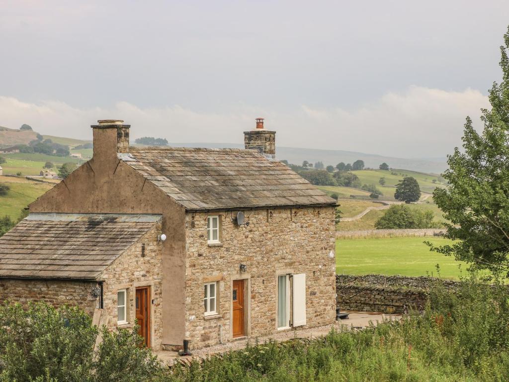 an old stone house on the side of a hill at The Aspens in Barnard Castle