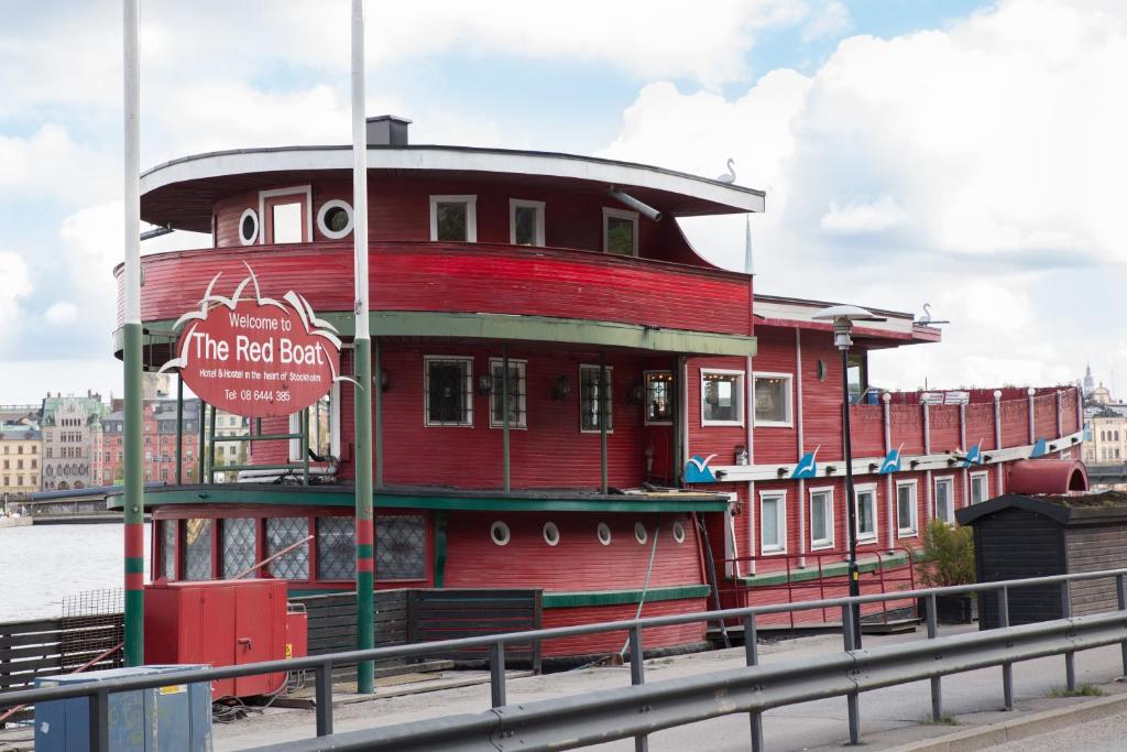a red building with a sign on the side of a bridge at Den Röda Båten in Stockholm