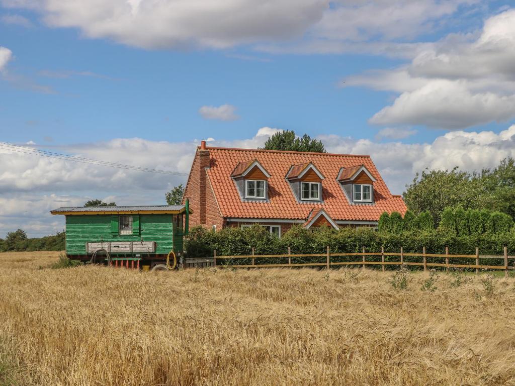 a house in a field with a green house at Wayside Cottage in York