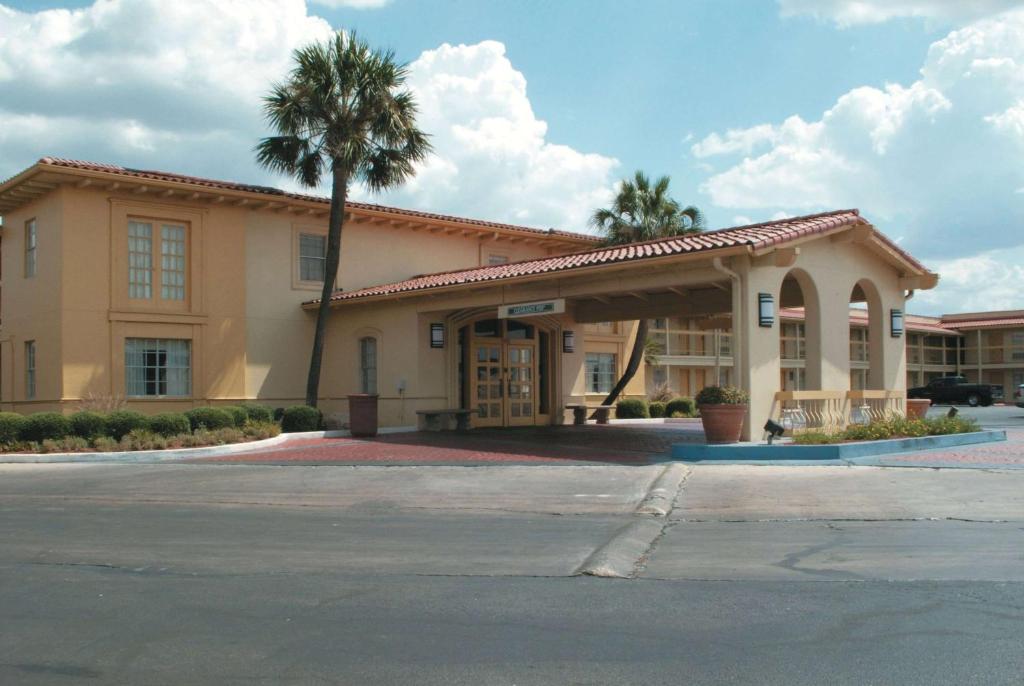 a building with a palm tree in front of it at Baymont by Wyndham San Antonio South Park in San Antonio