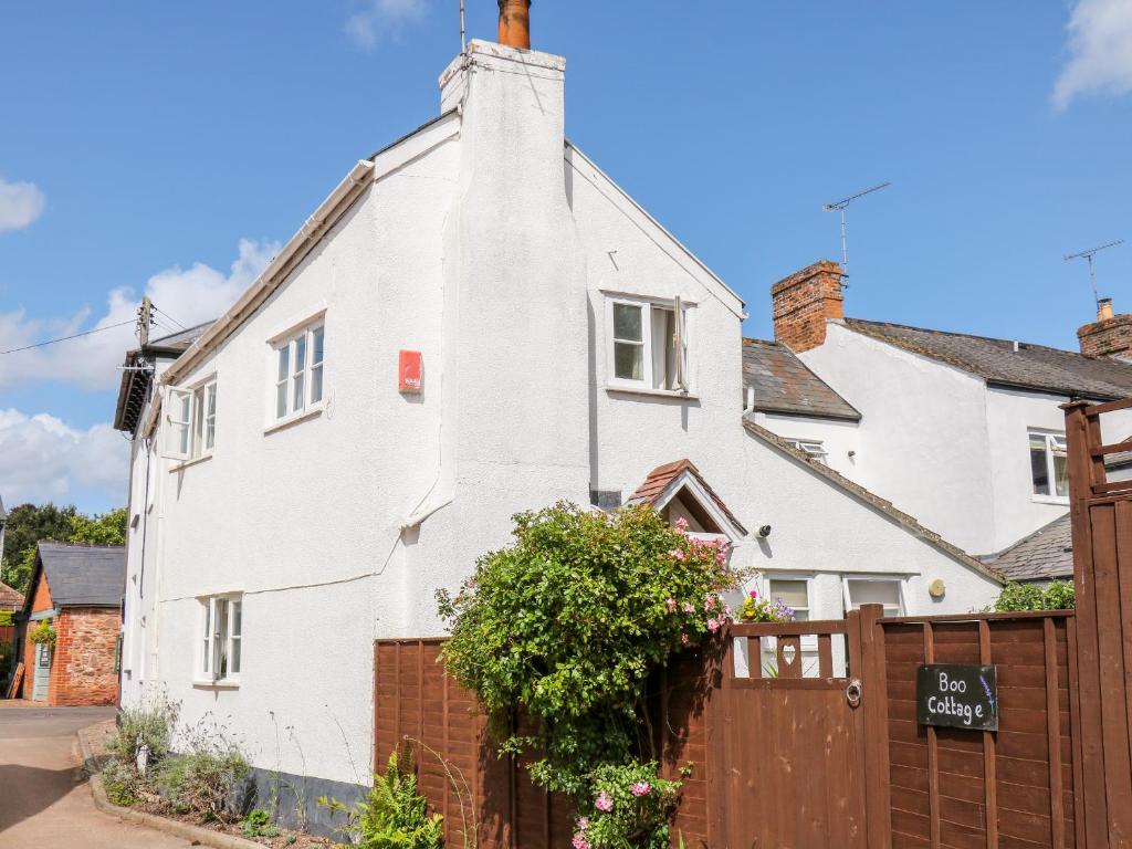 une maison blanche avec une clôture en bois dans l'établissement Boo Cottage, à Taunton