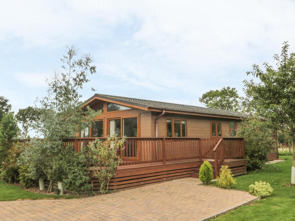 a home with a large deck and a house at Bulmer Farm Lodge in Malton