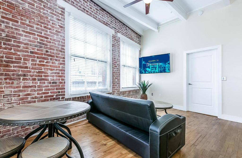a living room with a couch and a brick wall at Spacious Condos Steps Away from French Quarter in New Orleans
