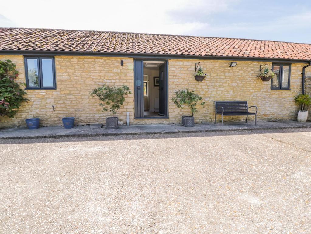 a house with a bench in front of it at Puddleducks in Sherborne