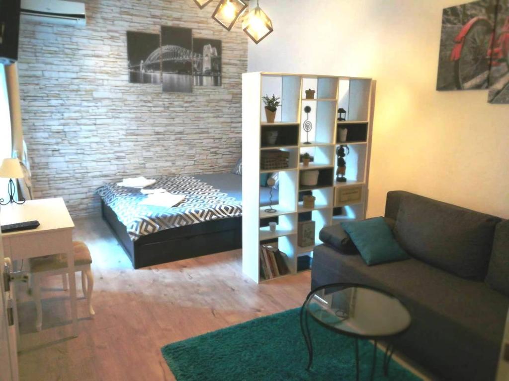 Saramala Apartment في بلغراد: غرفة معيشة مع أريكة ورف كتاب
