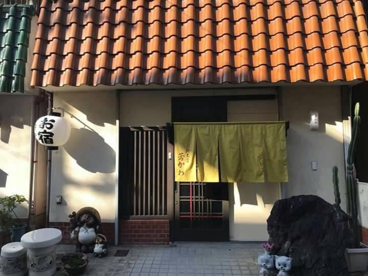 a house with a door with a yellow curtain on it at Guesthouse Yoshikawa in Nara