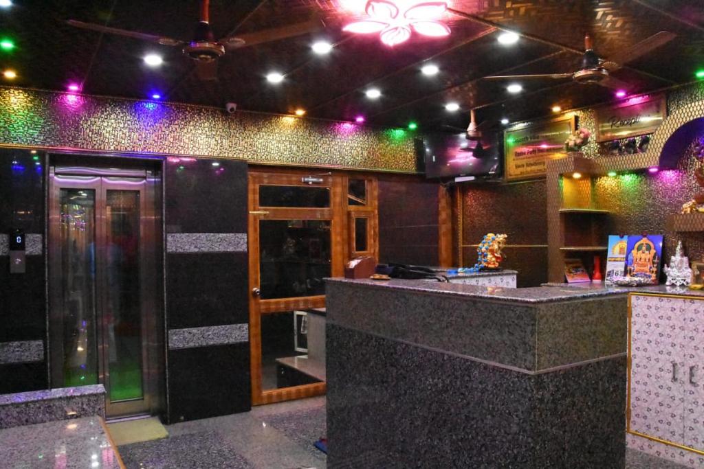 a bar in a restaurant with purple and green lights at Gayathri Stay in Kanchipuram