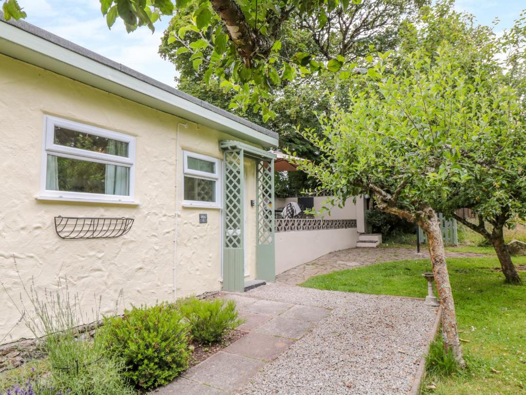 une maison avec un arbre en face dans l'établissement The Roost, à Camborne