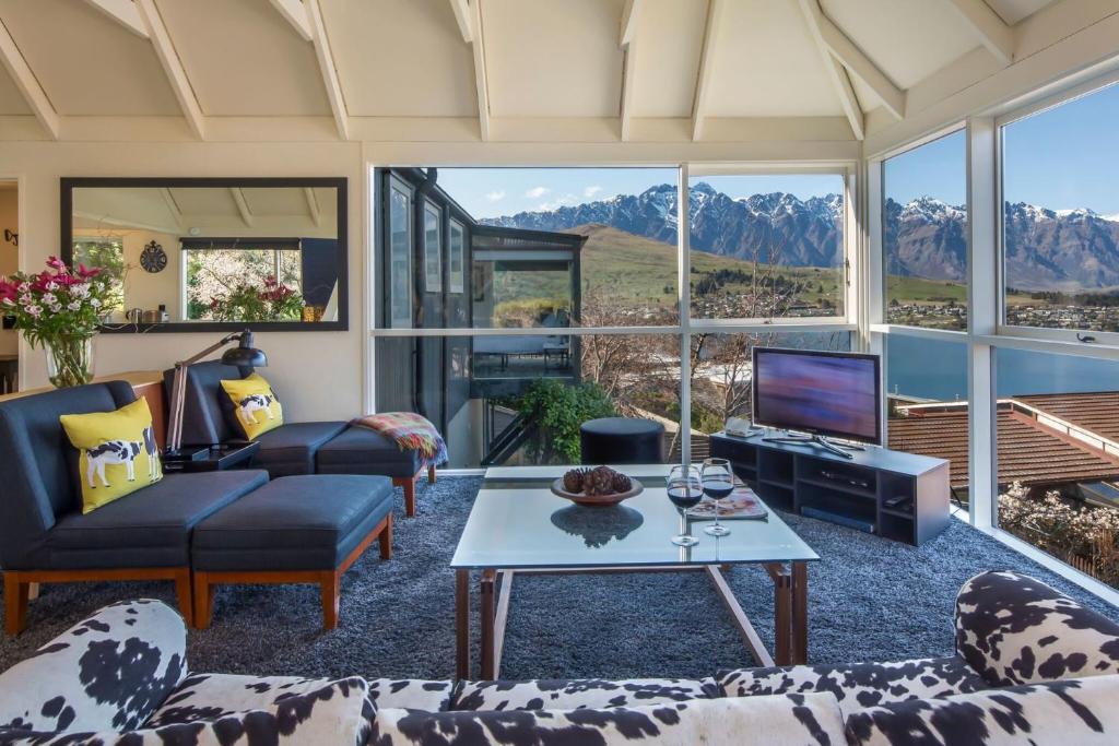 a living room with a view of mountains at Panoramic: farmhouse theme with shared spa pool in Queenstown