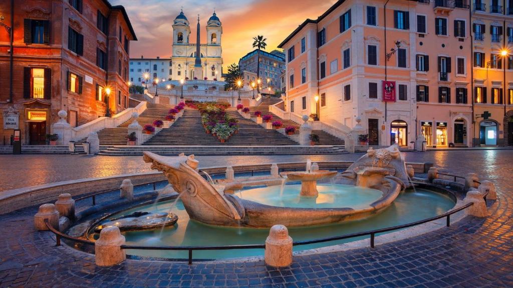 a city square with a fountain in the middle at Royal Piazza di Spagna in Rome